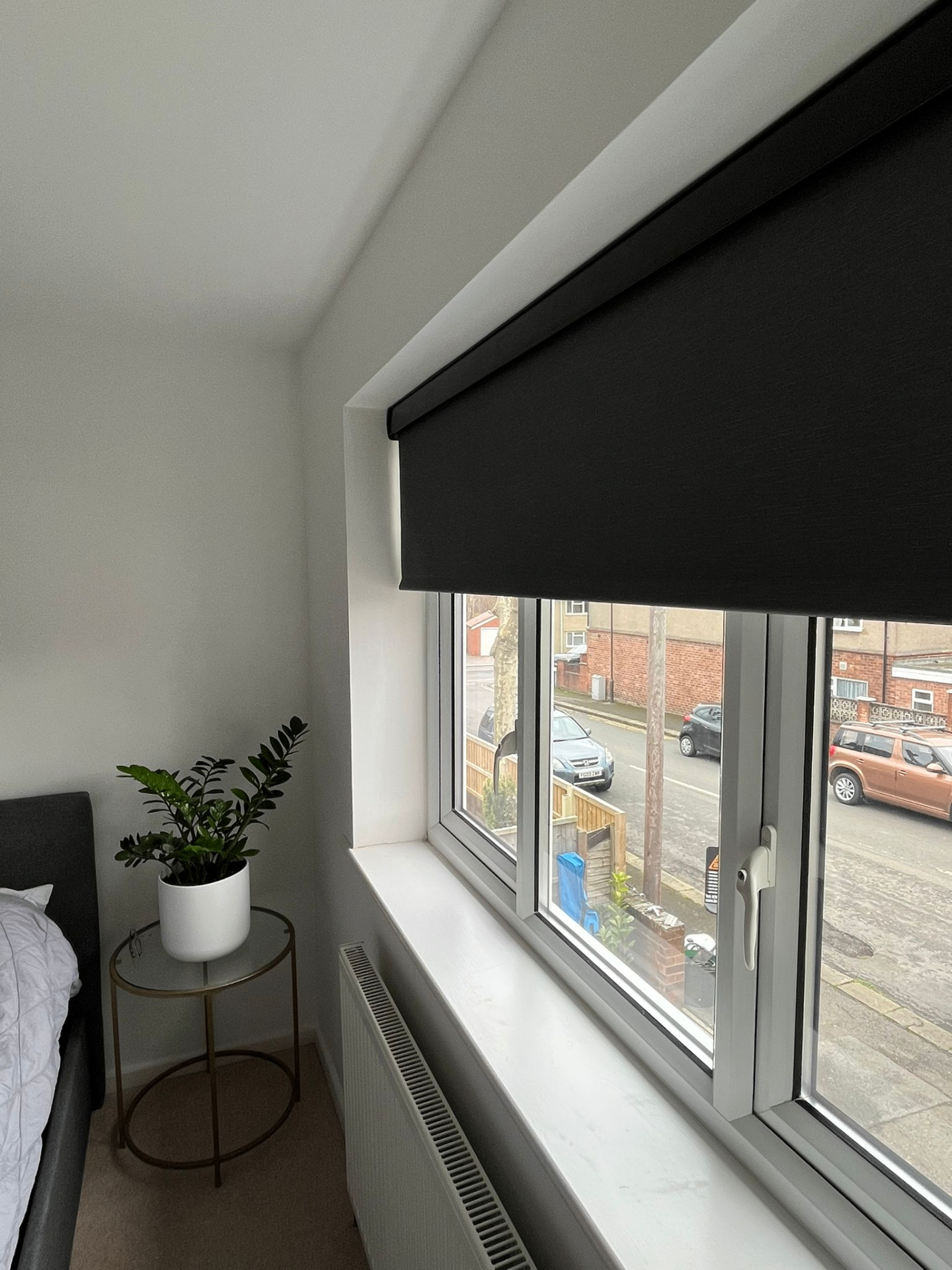 Dark blackout motorised roller blind fitted inside a bedroom dormer window
